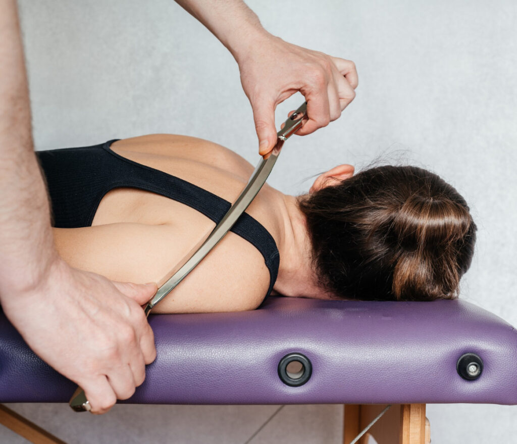 instrument assisted soft tissue mobilization on woman's back shoulder